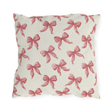 Rose pink engraved ribbon bows scattered on cream outdoor pillow