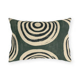 Black and cream concentric rings on a mottled forest green outdoor lumbar pillow