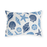 Coastal outdoor lumbar pillow with navy and sky blue seashells, starfish and sand dollars on white