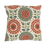Block print floral outdoor pillow with folk flower medallions in terracotta and sage green with leafy sprigs on cream