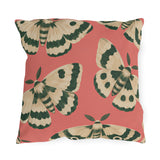 Pink outdoor pillow with large painted cream and forest green moths on coral pink