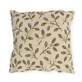 Olive leaves and pale snowberries block printed on a cream outdoor pillow