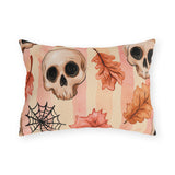 Halloween outdoor lumbar pillow with watercolor skulls, autumn leaves and a spider web on pink and peach stripes