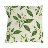 White pepper blossoms, green leaves and small chilies on a cream outdoor pillow