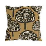 Black and cream block print trees on a warm ochre outdoor pillow