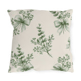 Green outdoor pillow with sage green eucalyptus sprigs tied with ribbon bows on cream