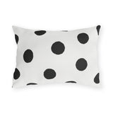 Black and white polka dot outdoor lumbar pillow with large hand-painted charcoal dots on warm white