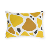 Yellow terrazzo outdoor lumbar pillow with large yellow and ochre stones and charcoal chips on white