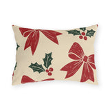 Red bows and green holly block printed on a cream outdoor lumbar pillow