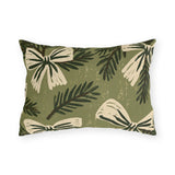 Cream bows and dark spruce sprigs on a soft sage green outdoor lumbar pillow