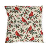 Christmas cardinal outdoor pillow with red cardinals, snowy pine sprigs, pinecones and red berries on soft cream