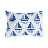 Coastal outdoor lumbar pillow with rows of cobalt and sky blue sailboats and waves on white