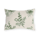 Green outdoor lumbar pillow with sage green eucalyptus sprigs tied with ribbon bows on cream
