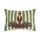 Sage green Christmas nutcracker outdoor lumbar pillow with a nutcracker, pine and a burgundy ribbon on sage and cream stripes
