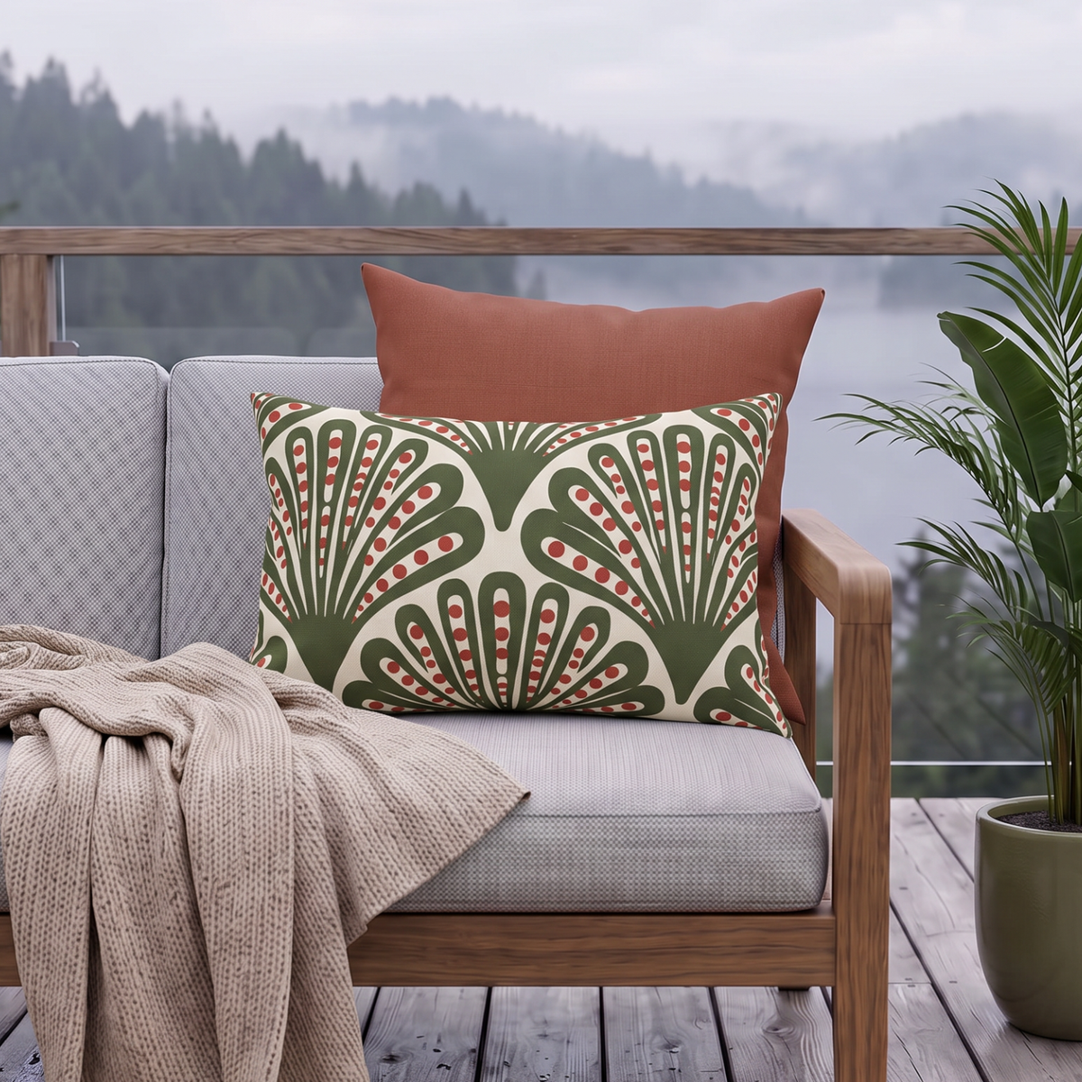 Green and red dotted fan outdoor lumbar pillow styled on a porch