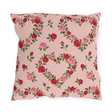 Blush pink outdoor pillow with heart-shaped wreaths of pink and red roses