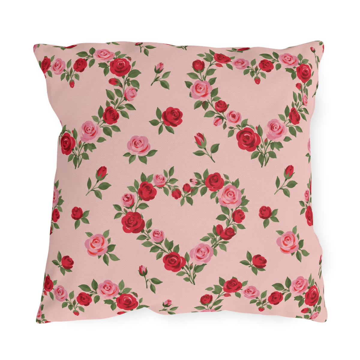 Blush pink outdoor pillow with heart-shaped wreaths of pink and red roses