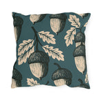 Cream and black block print acorns and oak leaves on a deep teal outdoor pillow