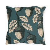 Cream and black block print acorns and oak leaves on a deep teal outdoor pillow