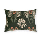 Cream cedar fronds and terracotta bows on a near-black forest green outdoor lumbar pillow