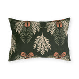 Cream cedar fronds and terracotta bows on a near-black forest green outdoor lumbar pillow