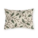 White snowberries on brown branches with green leaves on a cream outdoor lumbar pillow
