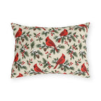 Christmas cardinal outdoor lumbar pillow with red cardinals, snowy pine sprigs, pinecones and red berries on soft cream