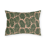 Dark green pine sprigs on blush peach outdoor lumbar pillow