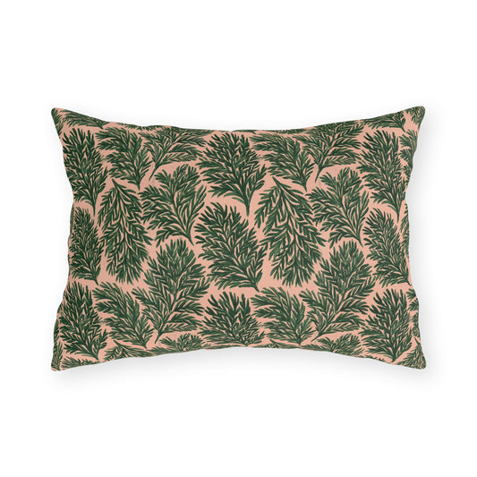 Dark green pine sprigs on blush peach outdoor lumbar pillow