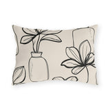 Black line-drawn plants in bottle vases on a cream outdoor lumbar pillow