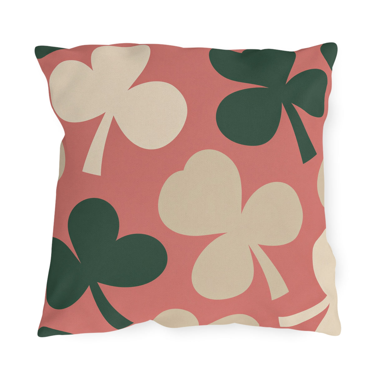 Modern outdoor pillow with oversized cream and forest green clover leaves on coral pink