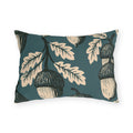 Cream and black block print acorns and oak leaves on a deep teal outdoor lumbar pillow