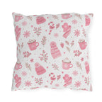 Pink beanies, mittens, cocoa mugs and snowflakes on white outdoor pillow