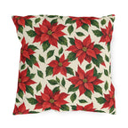 Christmas poinsettia outdoor pillow with red poinsettia blooms, golden centers and green leaves on warm cream