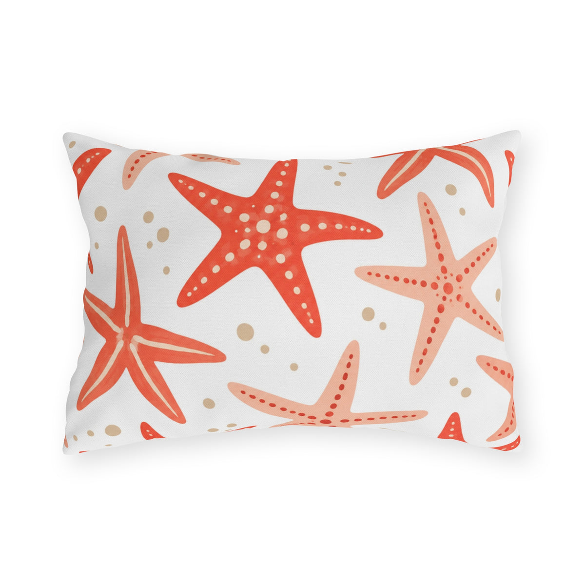 Coastal outdoor lumbar pillow with tossed coral and peach starfish and sandy dots on white
