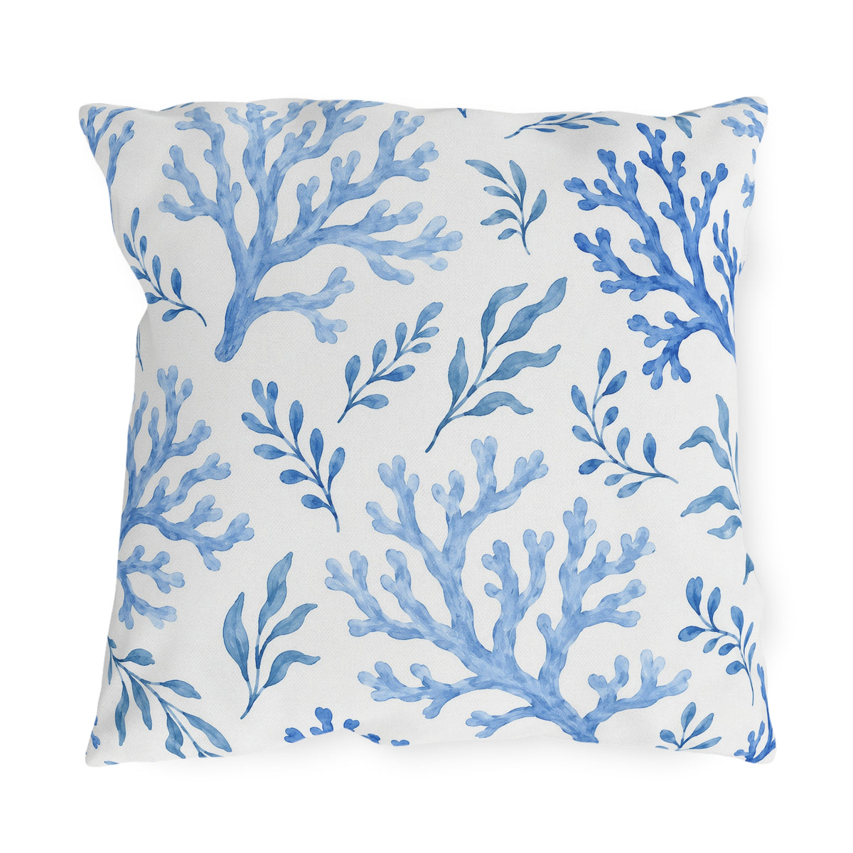 Coastal outdoor pillow with painted blue sea coral branches and seaweed sprigs on white
