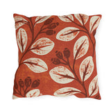 Cream leaves and dark rosehips block printed on a burnt terracotta outdoor pillow