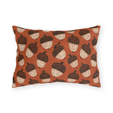 Block-printed cream and dark brown acorns on rust orange outdoor lumbar pillow