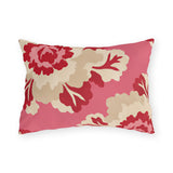 Floral outdoor lumbar pillow with oversized cherry red and cream peonies on bright pink