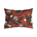 Navy sea holly thistles with cream heads on a brick red outdoor lumbar pillow