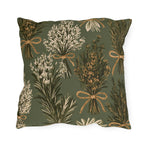 Rosemary, lavender and thyme bundles tied with twine on a sage green outdoor pillow