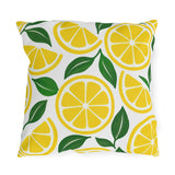 Yellow outdoor pillow with lemon slices and green leaves on white