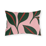 Modern outdoor lumbar pillow with oversized forest green leaves and red midribs on blush pink
