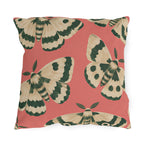 Pink outdoor pillow with large painted cream and forest green moths on coral pink