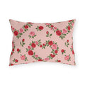 Blush pink outdoor lumbar pillow with heart-shaped wreaths of pink and red roses