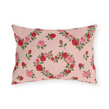 Blush pink outdoor lumbar pillow with heart-shaped wreaths of pink and red roses
