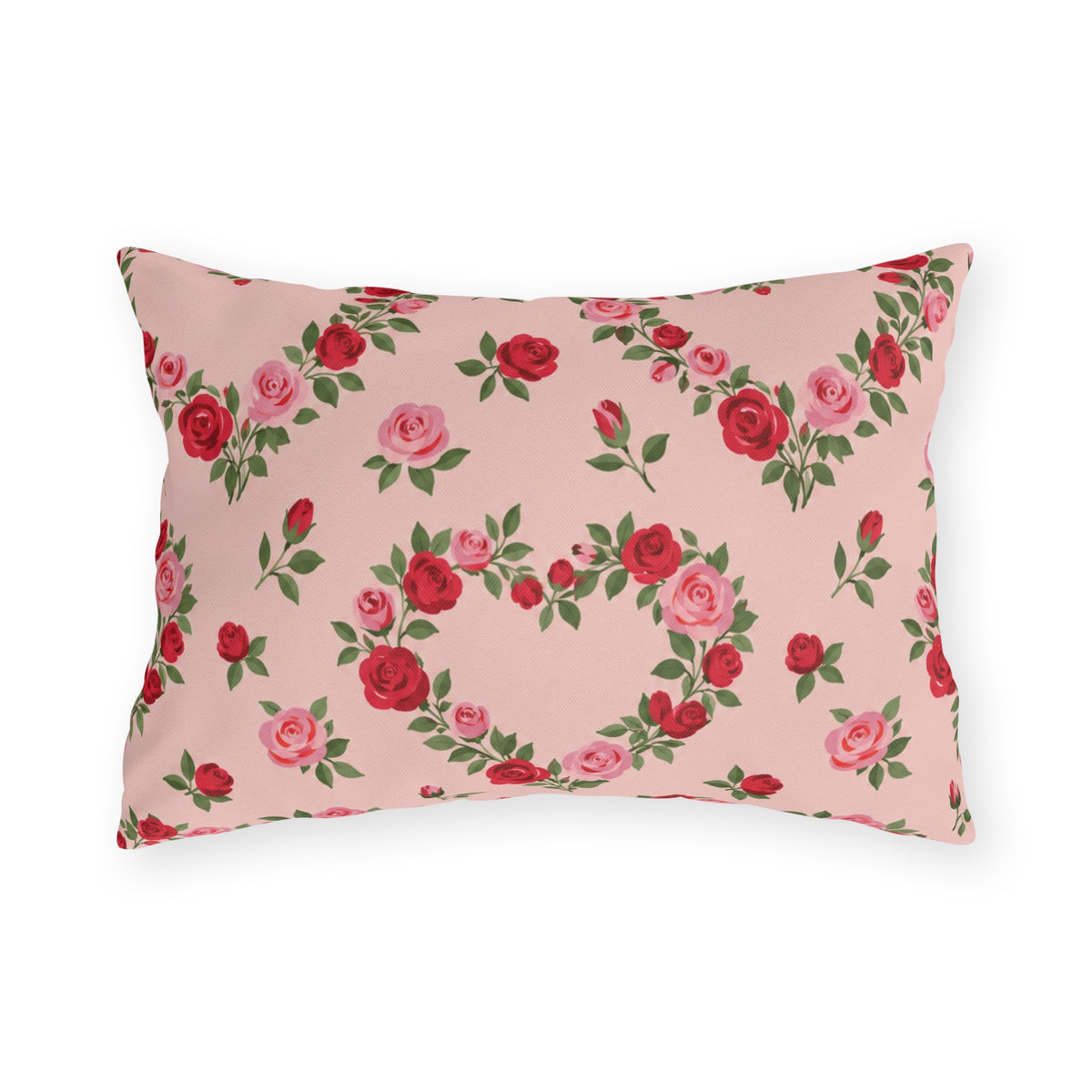 Blush pink outdoor lumbar pillow with heart-shaped wreaths of pink and red roses