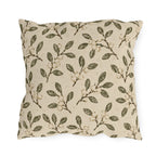 Olive leaves and pale snowberries block printed on a cream outdoor pillow