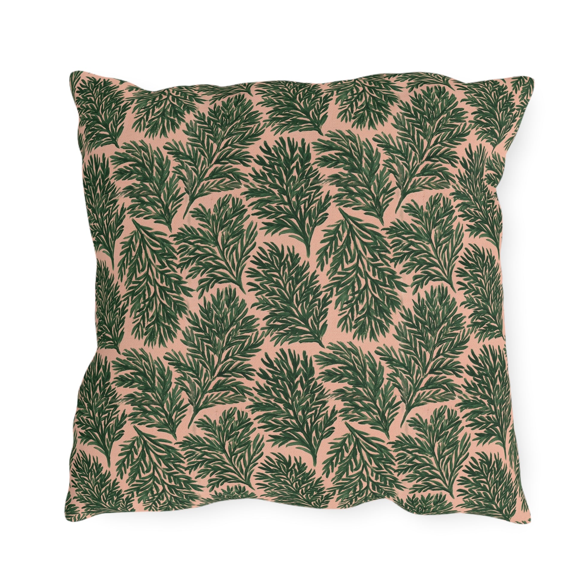 Dark green pine sprigs on blush peach outdoor pillow