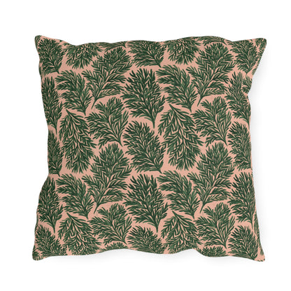 Dark green pine sprigs on blush peach outdoor pillow